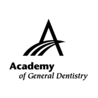 A black cat is sitting and looking forward against a black background.