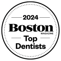Black and white circular badge reads “2024 Boston Magazine Top Dentists.”.